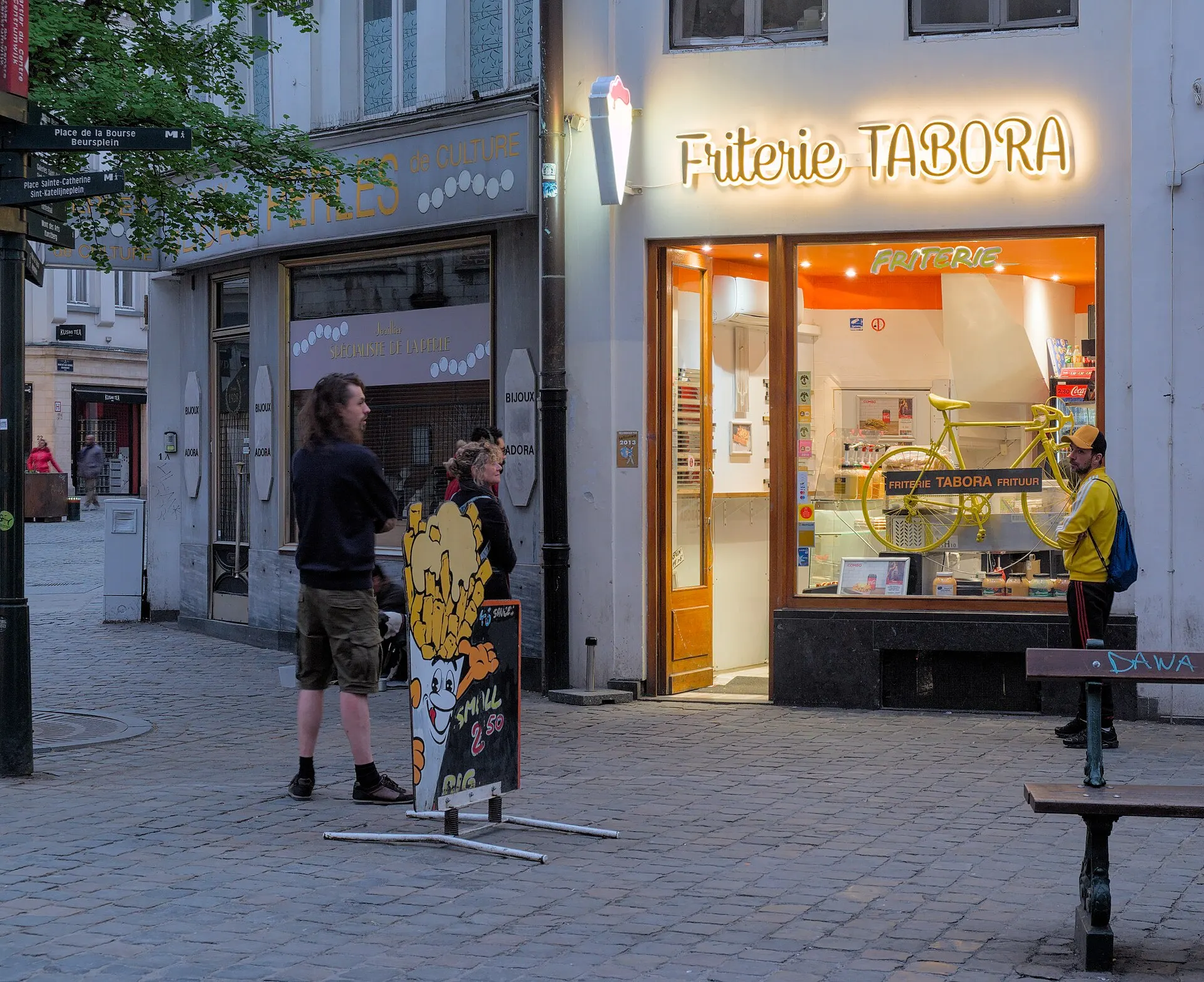 La devanture éclairée d'une friterie de Bruxelles, le soir